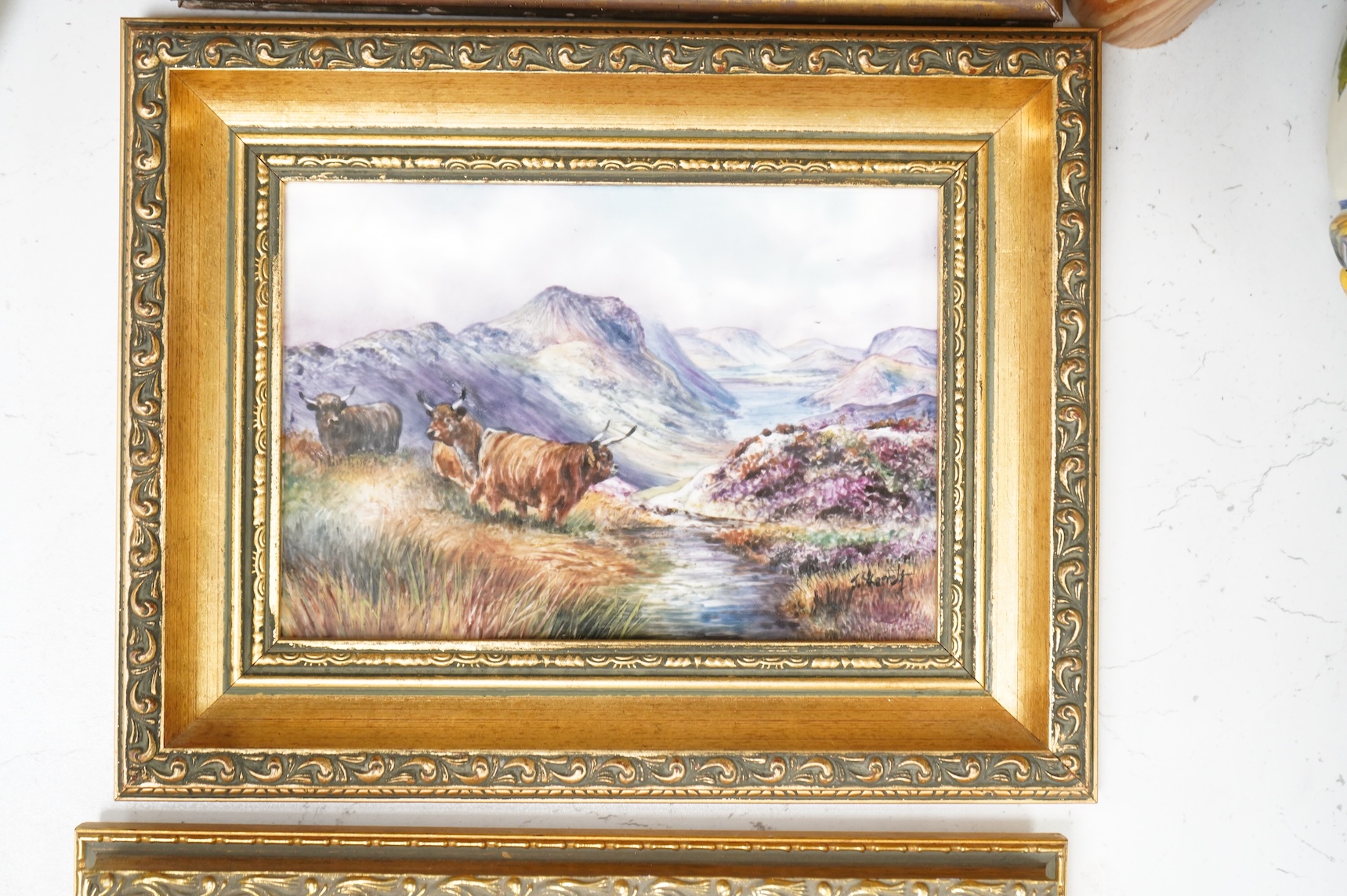 Four porcelain framed plaques, 19th and 20th century hand painted with highland landscapes and figures, two by James Skerrett, gilt framed, largest 21 x 26cm overall